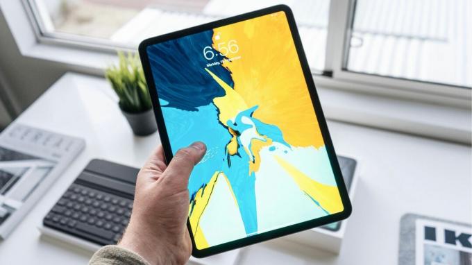 Держа iPad Pro с яркими обоями