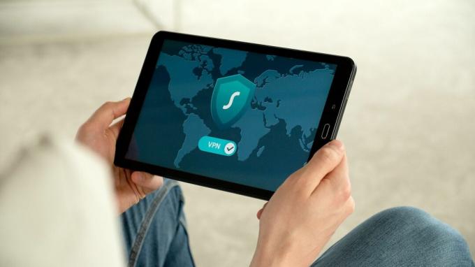 Человек, просматривающий Интернет на планшете с помощью VPN 