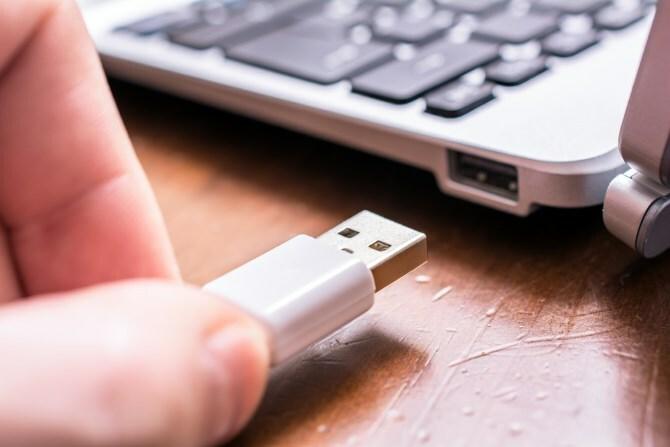 Человек отключает USB-устройство от компьютера